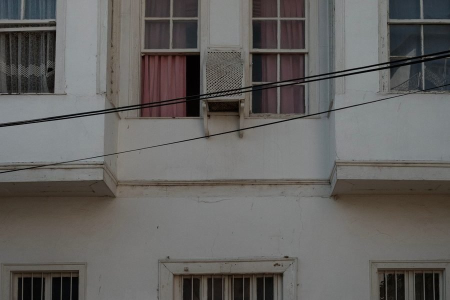 Fachada de um prédio residencial simples, com janelas e varandas